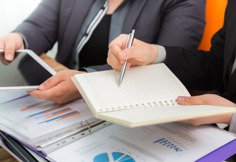 business-people-comparing-results-tablet-notebook